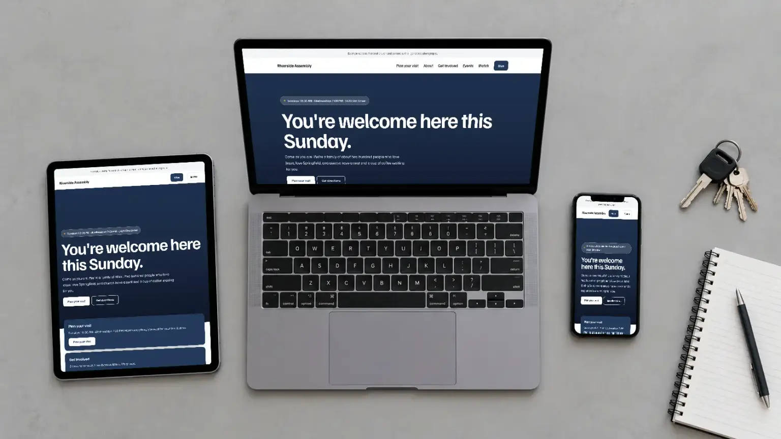 Illustrative photograph of a laptop, tablet and phone on a desk, each showing the same example church website.